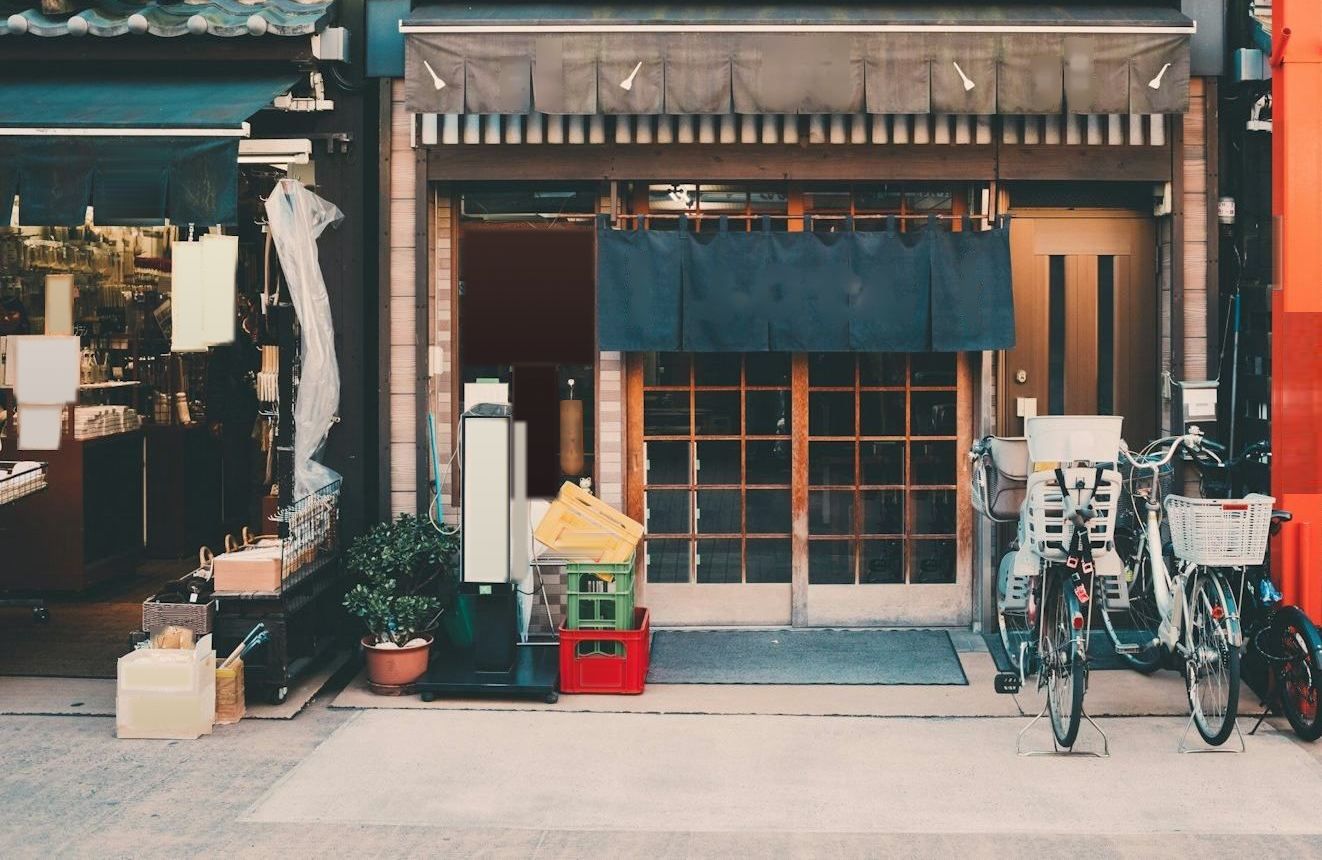 のれんのかかった町のお店の店先と、並んだ自転車